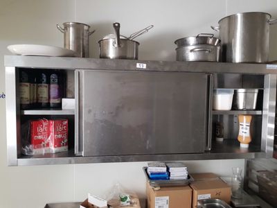 une cuisine avec plein de casseroles et de poêles accrochées au mur