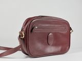 a close up of a brown leather cross body bag on a white background