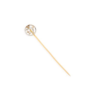 un gros plan d'une broche en or et diamants sur fond blanc