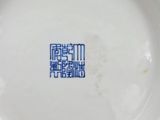 a white plate with blue writing on it on a table