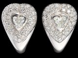 une paire de boucles d'oreilles en or blanc et diamants en forme de cœur sur fond noir
