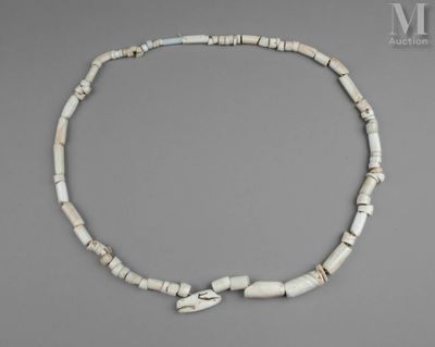 un gros plan d'un collier composé de perles blanches sur un fond gris