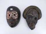 two masks that are on display on a white surface