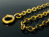 a gold chain with a ring on it on a black surface