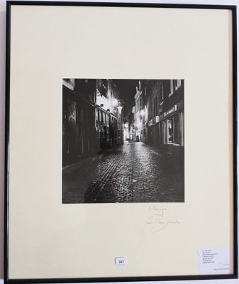 photographie en noir et blanc d'une rue où l'on voit une personne qui s'y promène