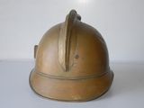 an old brass helmet on a white surface
