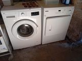 two washers and a dryer in a dirty room