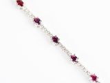 un gros plan d'un bracelet orné de pierres rouges sur fond blanc