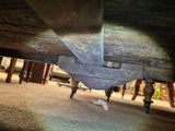 a close up view of a wooden bench under a wooden structure