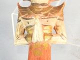 une figurine représentant une femme coiffée d'un chapeau