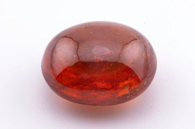 un gros plan d'une boule de verre rouge posée sur une surface blanche