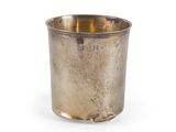 une tasse en argent posée sur une surface blanche