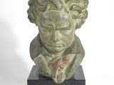 sculpture of a bust of a man with curly hair and a bow tie