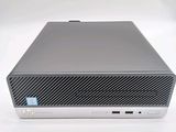 the front view of a silver hp desktop computer sitting on a white surface