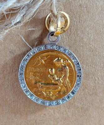an image of a gold and silver medal with a bird on it