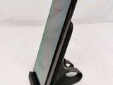 a close up of a cell phone on a stand on a table