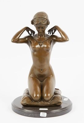 an image of a bronze statue of a woman sitting on top of a table