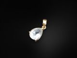 a gold pendant with a white stone on a black background