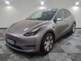 La Tesla Model Y argentée est garée dans une pièce au sol à carreaux.