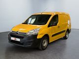 La camionnette jaune est garée dans une grande pièce au sol noir.