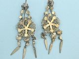 pair of silver and gold earrings with spikes on them
