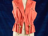 une veste orange sur un mannequin, sur fond bleu