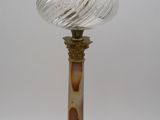 une lampe en verre posée sur un socle en marbre