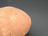 a hand holding a potato on a black surface