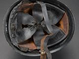 an old helmet with a fan attached to it on a gray surface
