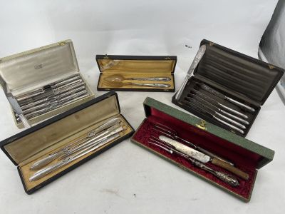 quatre types différents de couverts dans un coffret posé sur une surface blanche