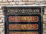 a black and red chest of drawers with a gold and red design