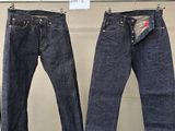 deux paires de jeans suspendues à un portant dans un magasin