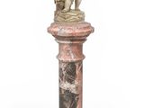 statue en marbre représentant un garçon tenant un panier, posée sur un socle