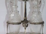 two glass decanters sitting on a silver stand