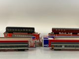 several model trains are lined up on a white surface