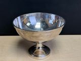 a silver bowl that is sitting on a wooden table