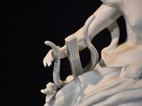 a white statue of a woman holding a harp