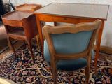 une table en verre avec une chaise bleue et un bureau en bois