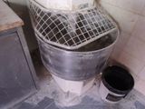 a toilet with a metal basket on top of it