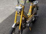 a small yellow bike parked on the side of the road