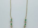un collier vert et doré orné d'une croix