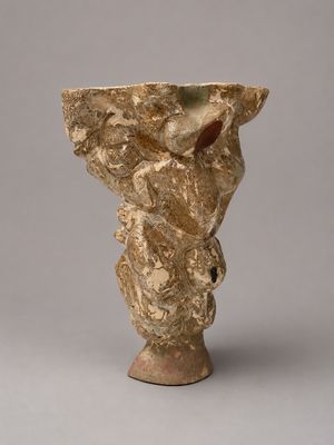 an image of a vase with a face on it on a gray surface