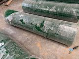 many rolls of green tarp sitting on the floor