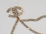 a gold chain with a flower on it on a white surface