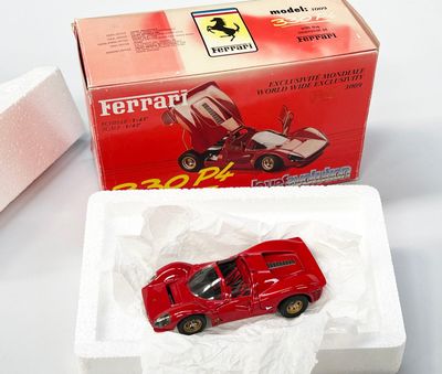 une petite voiture rouge dans une boîte blanche posée sur une table