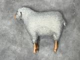 a sheep that is made of wool and wooden legs