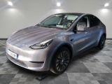 the silver tesla suv is parked on a checkered tile floor