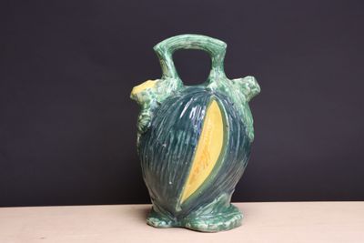 un vase vert et jaune posé sur une table