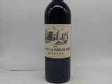 une vieille bouteille de vin posée sur une table blanche