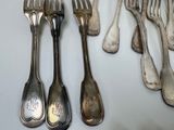 a lot of silver spoons and forks on the table